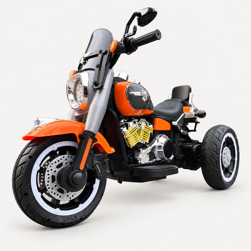 Country cruiser powerbike — Orange electric ride-on, front three-quarter, on a light-grey background.