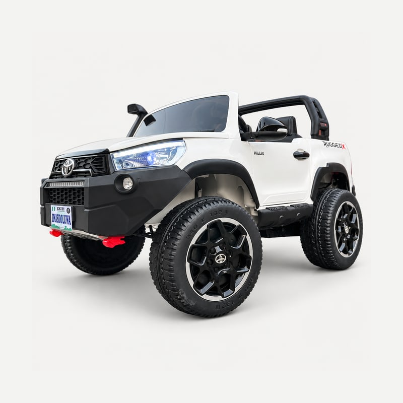 White Kids Hilux Rugged X electric ride-on car in a front three-quarter view, showing the bonnet, side door and wheels.